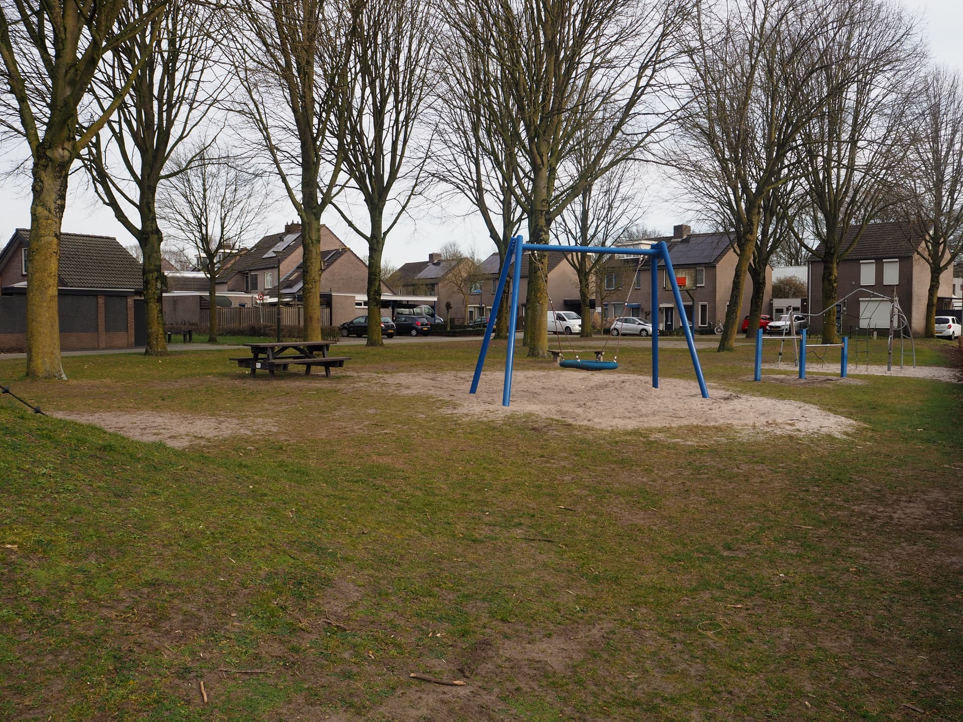 Enlarge image: on the left a picnic bench with a swing and tumble rack next to it with houses in the background